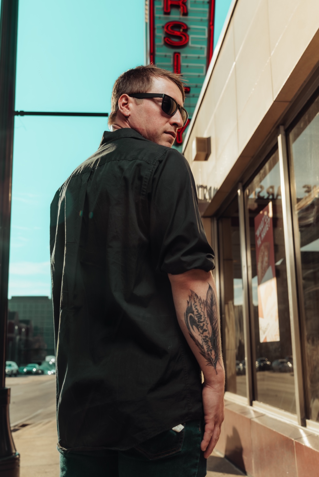 Lifestyle portrait beneath a downtown neon sign